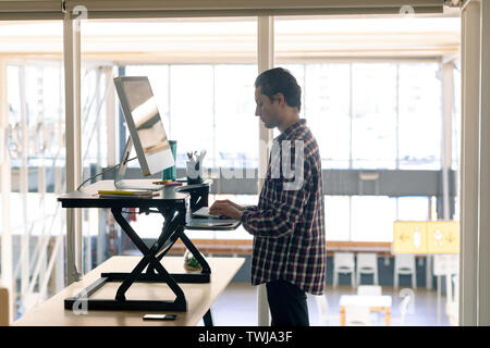 Male graphic designer working on computer at desk Stock Photo