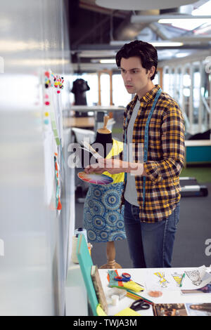 Male fashion designer looking at sketch in office Stock Photo