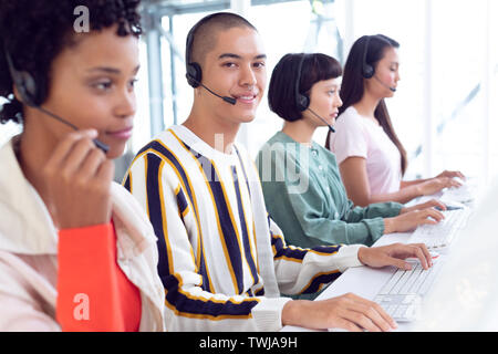 Customer service executives working on computer at desk Stock Photo