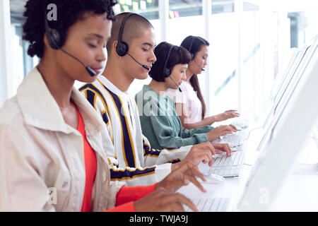 Customer service executives working on computer at desk Stock Photo