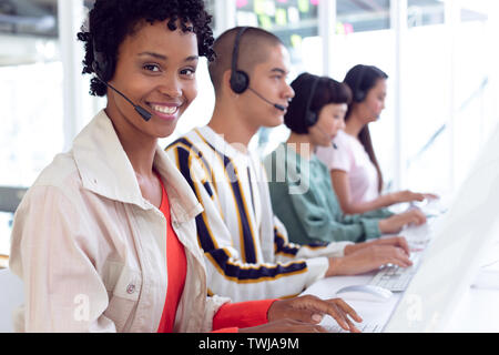 Customer service executives working on computer at desk Stock Photo