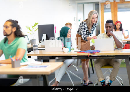 Business people discussing over laptop at desk in a modern office Stock Photo