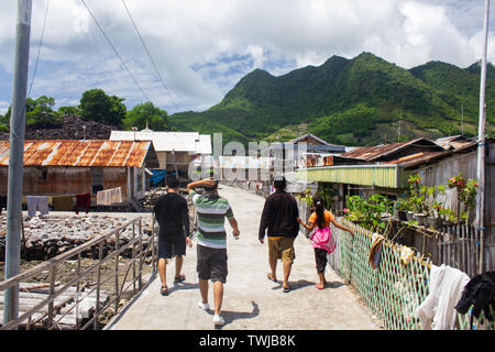 Some people were walking on the streets of Koja Doi village, Flores, among residents' houses with a backdrop of hills. Koja Doi is a small island in t Stock Photo