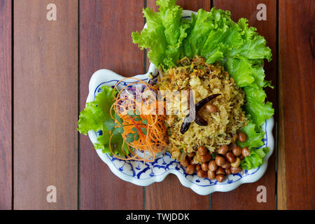 Yam Naem Khao Thot is Spicy Salad of Curried Rice Croquettes, Fermented Pork, Ginger and Peanuts on plate.Thai food Stock Photo