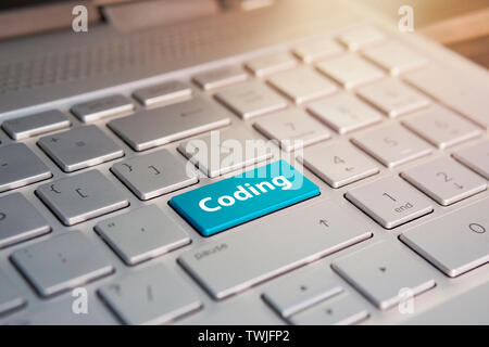 push button. blue button on grey silver laptop keyboard. copy space to test. presses a color button on a gray silver keyboard of a modern laptop. Stock Photo