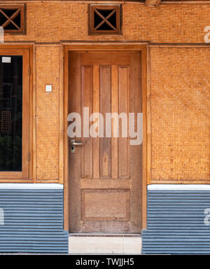 Wooden door with bamboo weaving wall Stock Photo