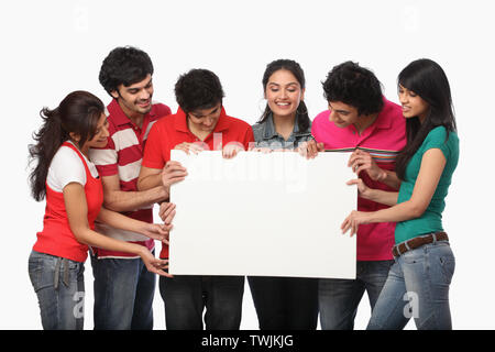 Group of friends holding a placard and smiling Stock Photo