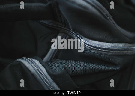 Abstract picture of black fabric travel bag with gray plastic zippers Stock Photo