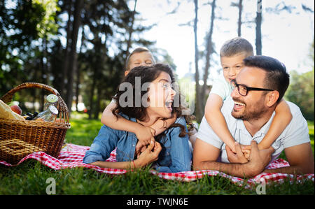 Happy young family enjoying picnic in nature Stock Photo