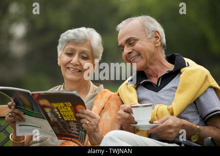 Old couple reading a magazine Stock Photo