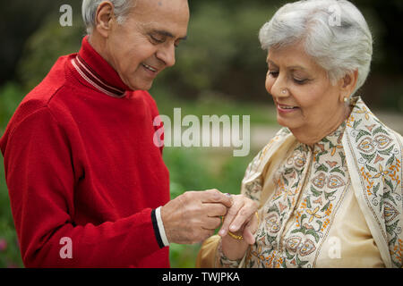 Old man placing ring on woman finger Stock Photo