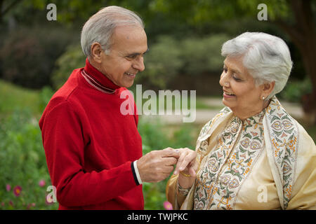 Old man placing ring on woman finger Stock Photo