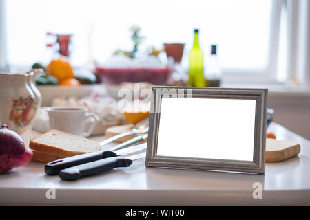 Blank picture frame with ingredient cooking on dining table Stock Photo