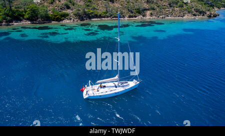 Aerial view of sea and yacht. Sailing ship in the middle of ocean, top view, summer background. Amazing view to Yacht sailing in open sea at sunny day Stock Photo