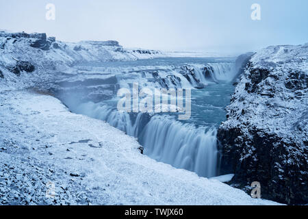 The impressive and beautiful Gulfoss Waterfall in Iceland is absoutely amazing even with bad cloudy weather and at snowfall. Stock Photo