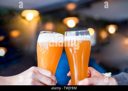Enjoy clinking draft beer with friends in pub Stock Photo