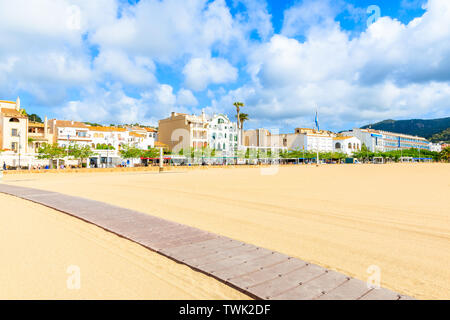Path on sandy beach in Tossa de Mar with colorful houses in background, Costa Brava, Spain Stock Photo
