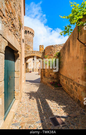 Narrow street and castle gate in historic old town of Tossa de Mar, Costa Brava, Spain Stock Photo