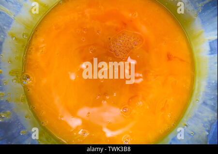 Orange color fluid of yolk stir in stainless bowl Stock Photo