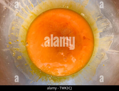 Orange color fluid of yolk stir in stainless bowl Stock Photo