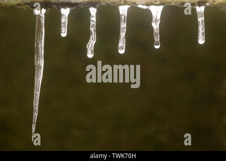 A Row of Icicles hanging from the edge a Roof Stock Photo