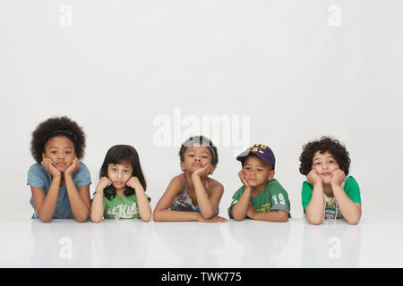 Group of children leaning on elbows Stock Photo