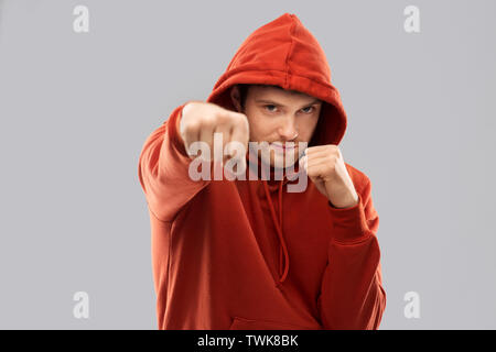 man in red hoodie fighting with fists or boxing Stock Photo Alamy