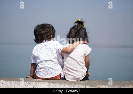 Boy and little girl sitting near lake, Veer dam, Pune, Maharashtra, India. Stock Photo