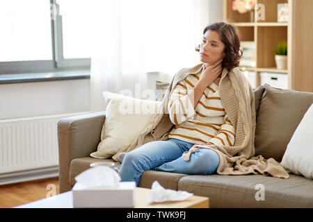 unhappy sick woman with sore throat at home Stock Photo