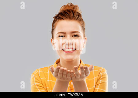 happy red haired teenage girl holding empty hands Stock Photo