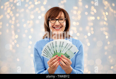 senior woman with hundreds of euro money banknotes Stock Photo