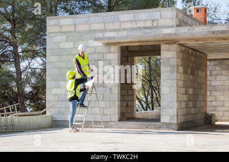 Foreman and his young apprentice on a construction site visit, house under construction Stock Photo