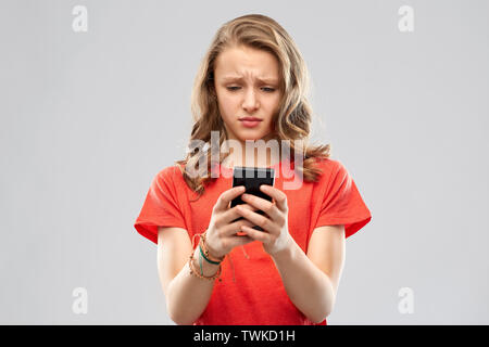 sad teenage girl using smartphone Stock Photo