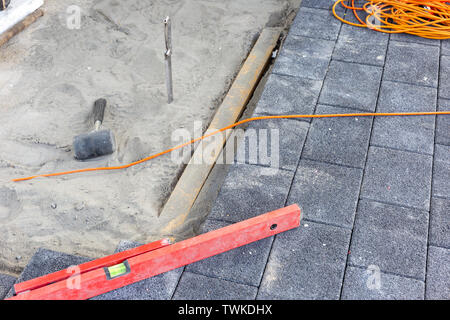 laying paving stones on the terrace with tools Stock Photo