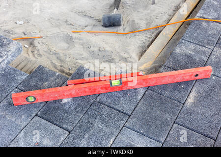 laying paving stones on the terrace with tools Stock Photo