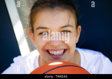 Portrait of a beautiful and young female basketball player smiling Stock Photo