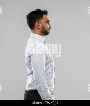 indian businessman side view over grey background Stock Photo
