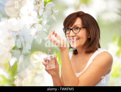 senior woman smelling perfume from her wrist Stock Photo