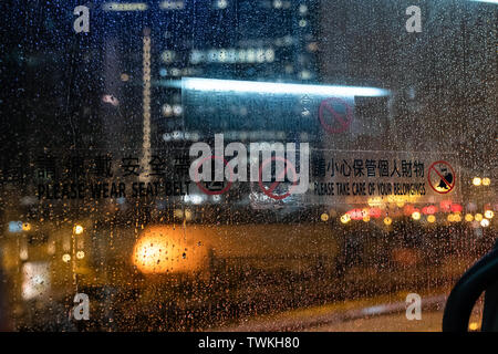 Looking through window on bus with light on road in a rainy day Stock Photo