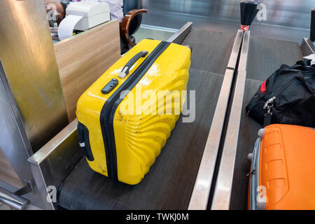 Yellow large luggage on belt at counter check-in airline Stock Photo