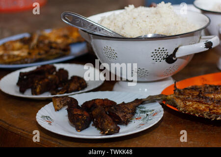 Home-cooked dinner menu from a fishing village in Flores Indonesia. Rice as the main food with side dishes in the form of fried fish Stock Photo