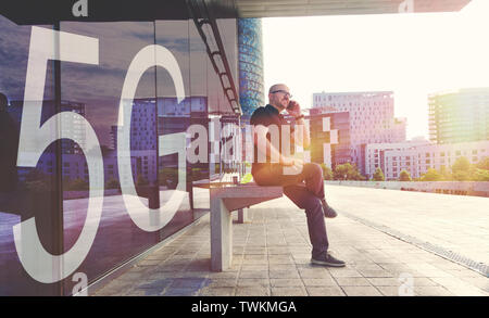 Young businessman using a smartphone with the new 5G mobile network. Urban scene in the street and empty copy space for Editor's text. Stock Photo