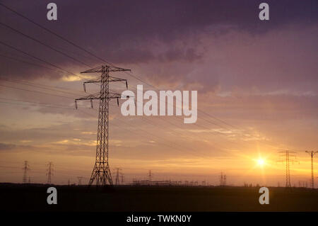 Energy pole on dramatic sunset sky. Electric distribution. Stock Photo