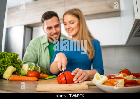 Young couple is preparing meal in their kitchen. Stock Photo