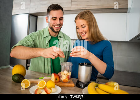 Young couple is preparing juice in their kitchen. Stock Photo