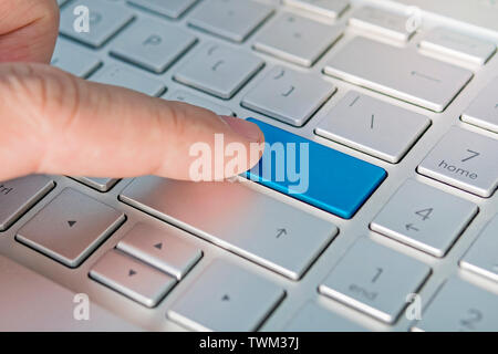 Close up of computer laptop keyboard with a blank blue button for any message and copy space. Conceptual image of an alert, danger, warning, announcem Stock Photo