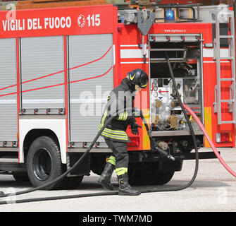 Rome, RM, Italy - May 23, 2019: fireman with helmet and the fire truck with text VIGILI DEL FUOCO that means Firemen in Italian language Stock Photo