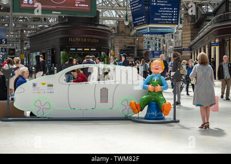 Glasgow, Scotland, UK. 21st June, 2019.Yer Green Laddie, created by 24 Design Ltd. ‘Yer Green Laddie’ is looking to get his car charged before travelling around Scotland on his BIG Bucket Trail… but he needs your help! Spin the turbines to get him and his car on the go with ‘Green Power’. The sculpture is part of Oor Wullie’s BIG Bucket Trail. Credit: Skully/Alamy Live News Stock Photo