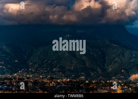 An aerial view of Kathmandu City in golden hour with stormy clouds at the top of The Himalayas Stock Photo