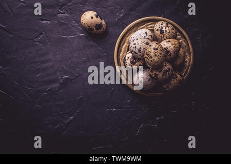 Small Quail Eggs on Dark Stone Background Stock Photo